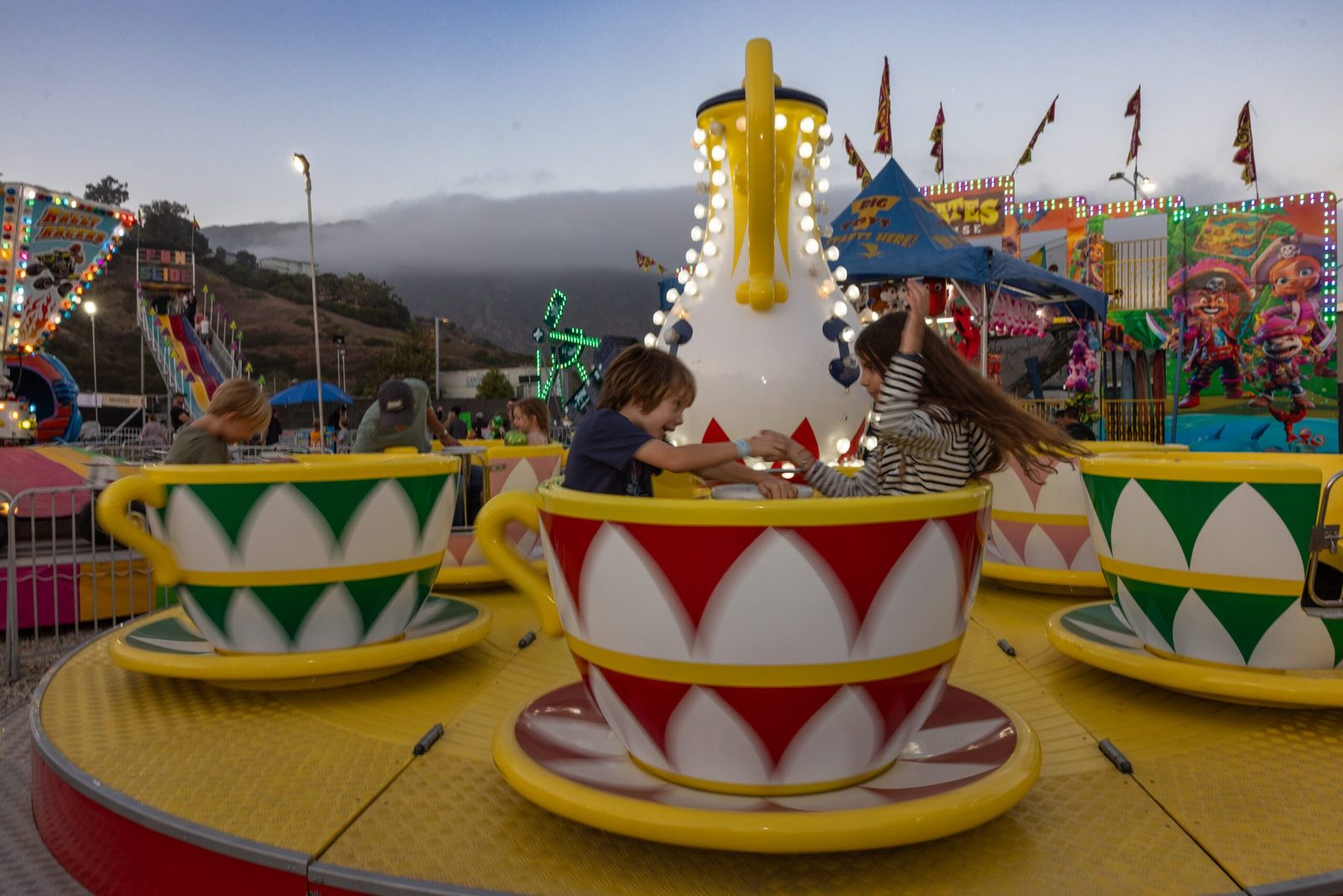 Kids laughing in the spinning teacup ride at the Malibu Chili Cook-Off